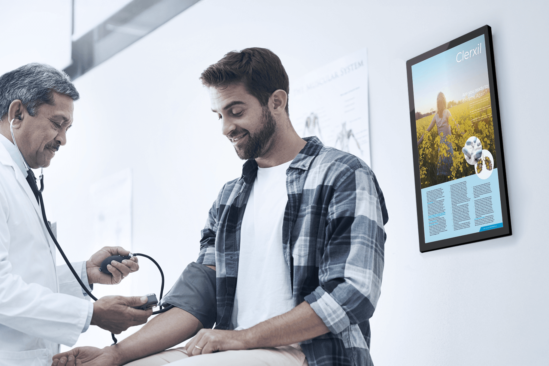 Doctor checking a patient's blood pressure, with an exam room screen beautifully displayed beside them